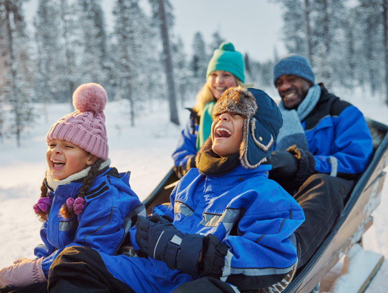 family laughing together in snow